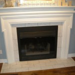 Fireplace insert with mantel, trim and tile on floor and wall.